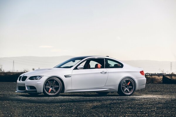 BMW blanc sur le côté sur un fond de ciel clair