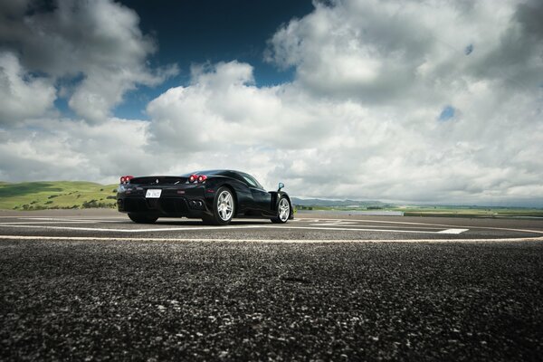 Black Ferrari rear view from the side of the road