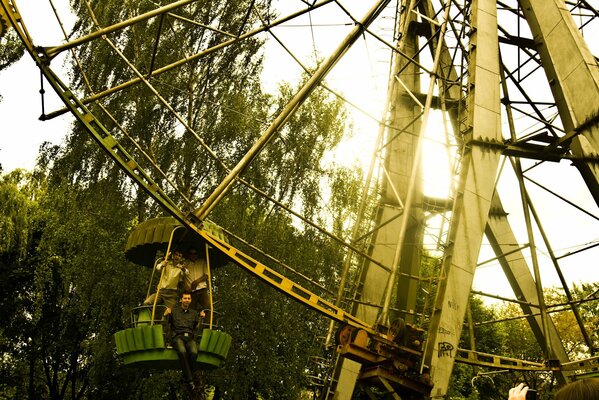 Mann auf einem Riesenrad auf einem Hintergrund von Bäumen