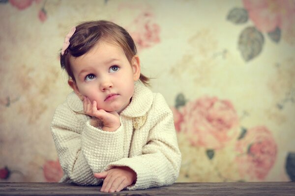 A thoughtful child is sitting at the table