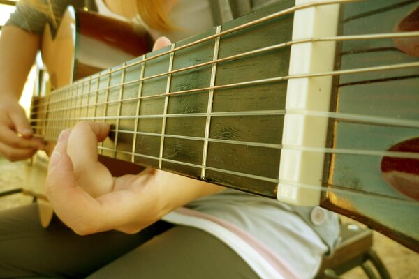 Diapasón de la guitarra. Cuerdas de guitarra. Guitarrista. Acorde. Chica con guitarra