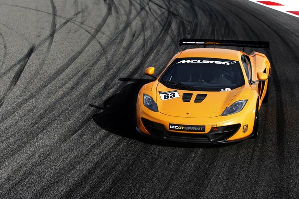 Voiture orange sur piste sportive