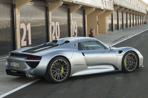 In der Nähe der Garage ist ein grauer Porsche auf Asphalt