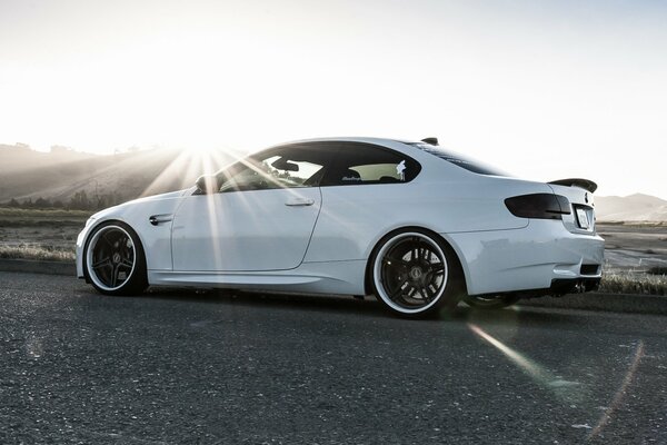 BMW blanc au coucher du soleil dans le profil