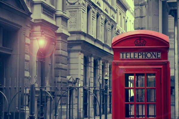 Red telephone booth in London against the background of gray buildings