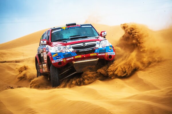 The SUV is flying through the sand in the desert race