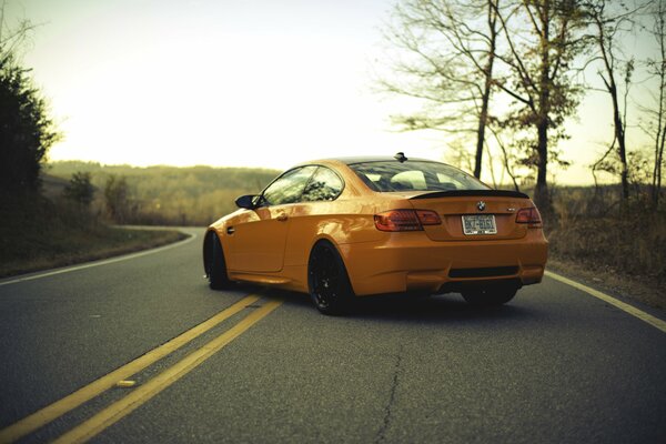 Voiture orange se trouve sur une route plate