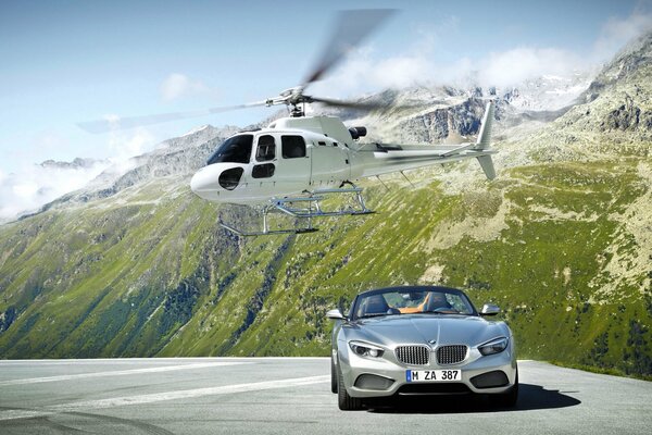 Helicóptero y BMW gris en las montañas