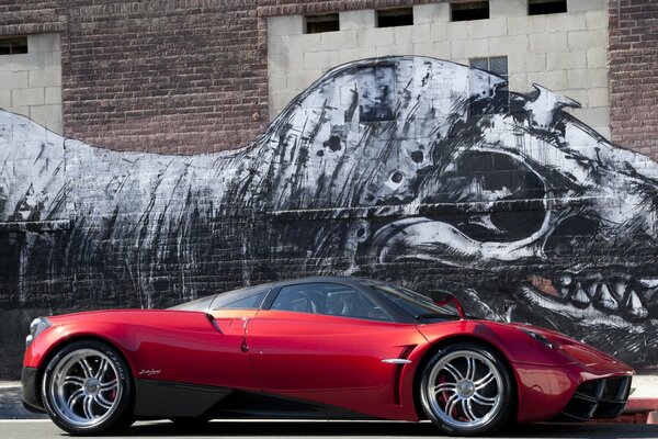 Czerwony pagani huayra i rysunek dinozaura