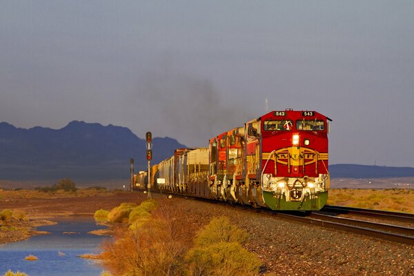 Locomotora diesel roja en el fondo del paisaje de otoño