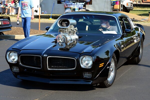 A 1975 black pontiac with a supercharger