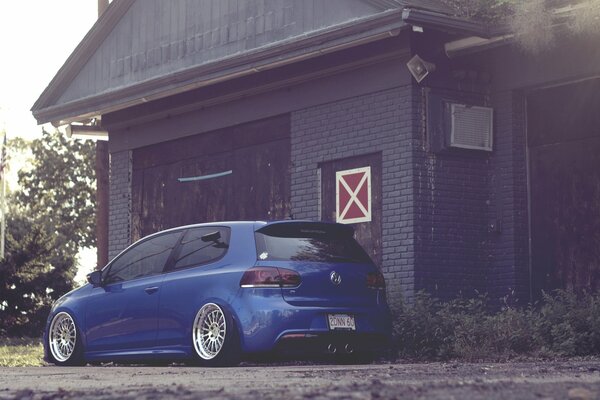 Una foto inusual del coche. Hermosa foto de coche. Auto azul. El coche está cerca de la casa. Volkswagen