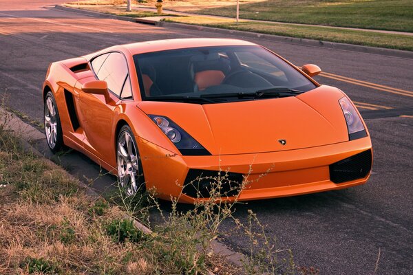 Pomarańczowy Lamborghini wzdłuż drogi Widok Z przodu