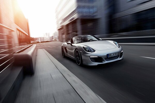 A chic Porsche convertible rushes through the city