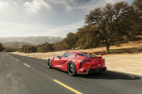 A red Toyota concept car is driving on the road