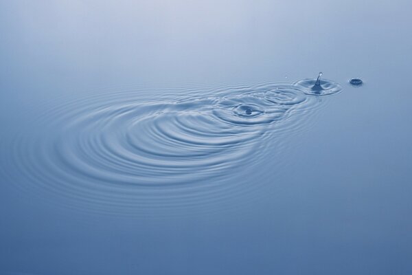 Gouttes qui tombent dans l eau bleue