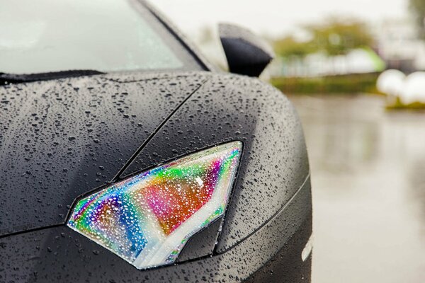 Lamborghini Aventador mojado. Faro en gotas de arco iris