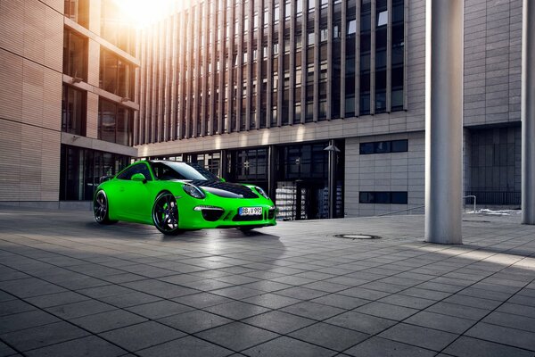 Green Porsche Carrera sports car in the city