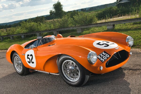 Naranja Aston Martin en el camino rural