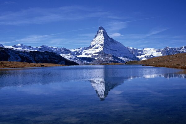 Ein riesiger Schneeberg spiegelt sich im See wider