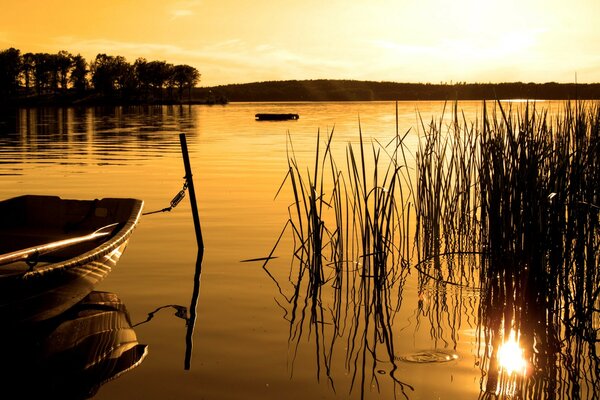 Bateau dans un lac tranquille au coucher du soleil