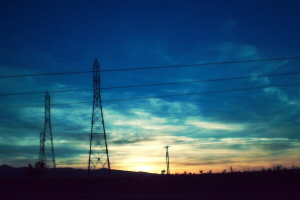 The sun going over the horizon on the background of towers