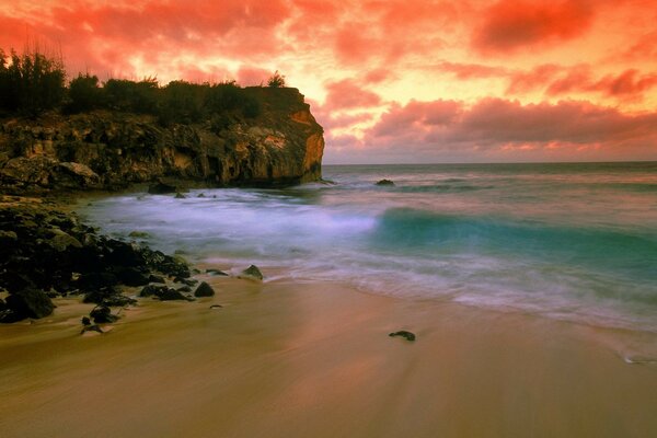 Sonnenuntergang am Strand Felsen und Meer