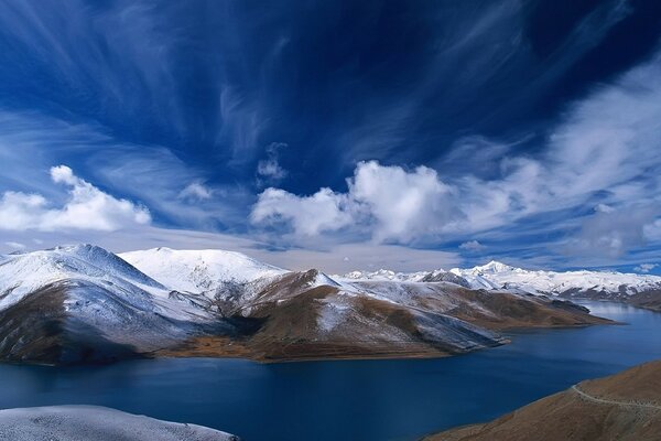 El río fluye entre las montañas cubiertas de nieve