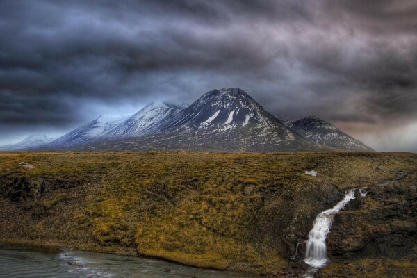 Cascada de montaña desemboca en el río