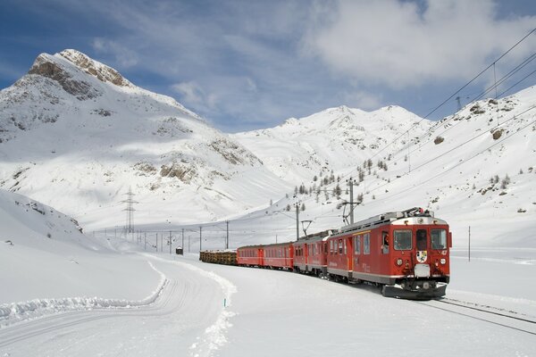 Train rouge en hiver dans les montagnes