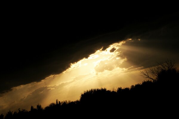 Die Sonnenstrahlen spähen aus einer dunklen Wolke