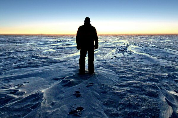 Ein Mann bewundert den Sonnenuntergang in der Antarktis
