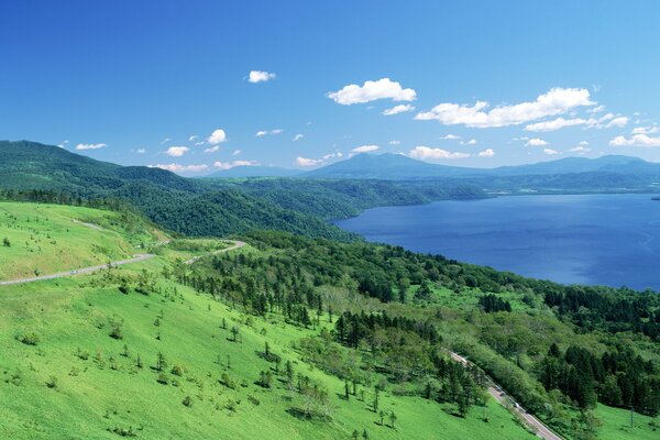 Krajobraz Hokkaido w Japonii. Trawa, błękitne niebo i woda