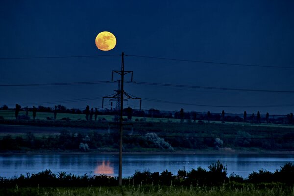 Eine mystische Landschaft mit einem Mond, der sich im Wasser widerspiegelt