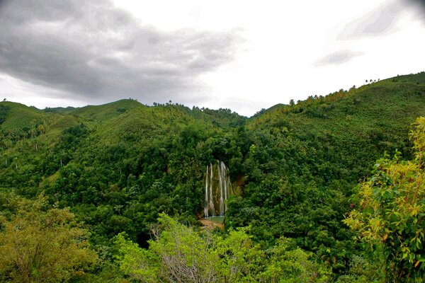 Wasserfall im Dschungel vor dem Hintergrund der Wolken