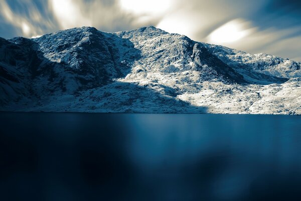 Blaue Oberfläche des Meeres vor dem Hintergrund der schneebedeckten Berge