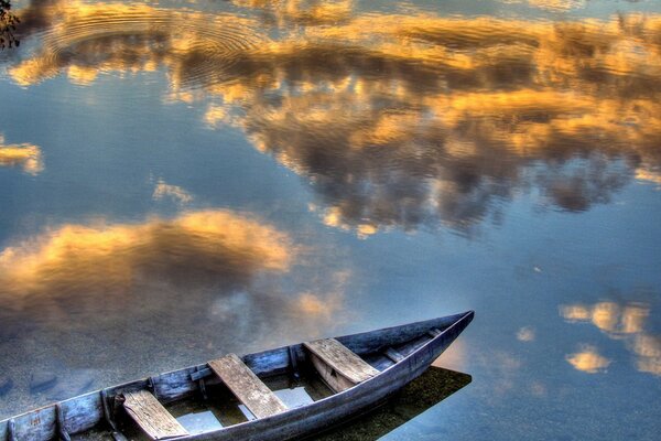 Boot auf dem Hintergrund der Reflexion der schwebenden Wolken