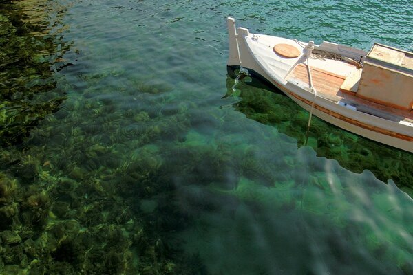 Barco en el mar en el que se puede ver el fondo