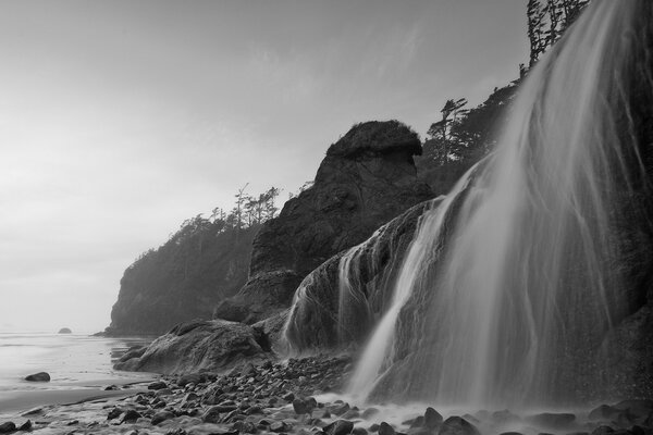 Foto monocromatica di una cascata che cade sulle rocce