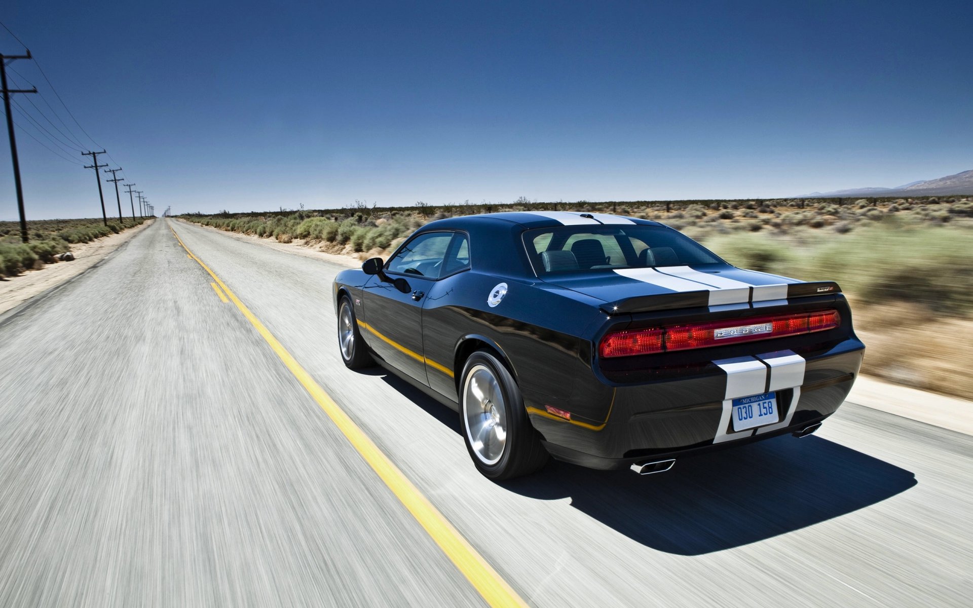 dodge challenger machine in motion black of the strip road day