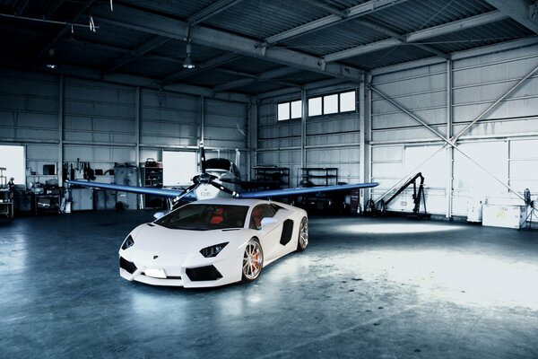 Hangar con avión y Lamborghini blanco