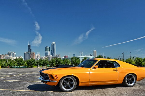 Żółty Ford Mustang na tle miasta