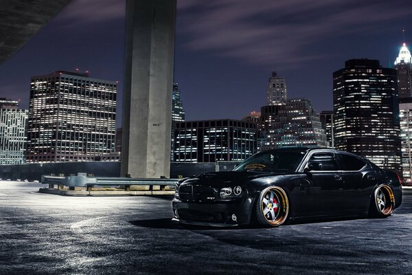 Dodge negro en el fondo de la ciudad de la noche