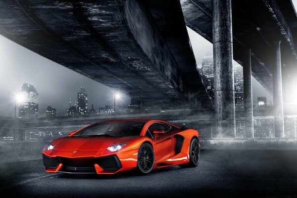 Lamborghini arancione alla luce della città notturna