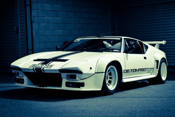 White supercar on a blue wall background