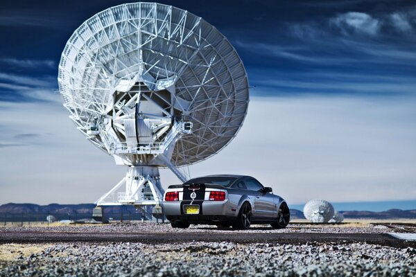 Fondo de pantalla con un ford mustang plateado en el fondo de la antena