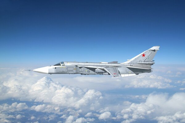 Bombowiec Su-24 leci na niebie nad chmurami