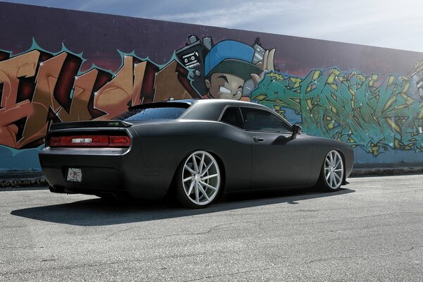 Black matte challenger against the wall with graffiti