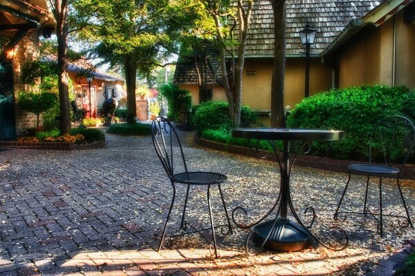 Table and chairs on the pavement near the house