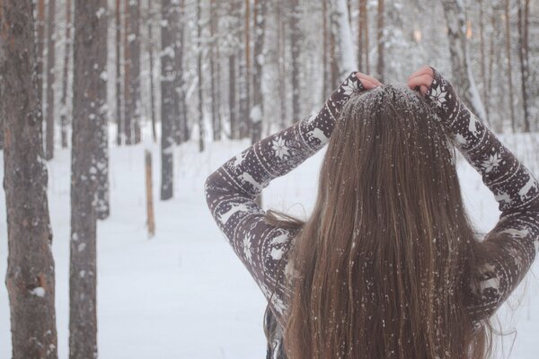 Charmante jeune fille sous la neige dans la forêt blanche comme neige